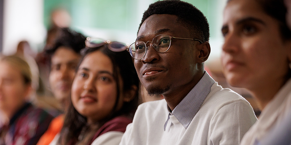 Students sit looking toward an unseen presenter