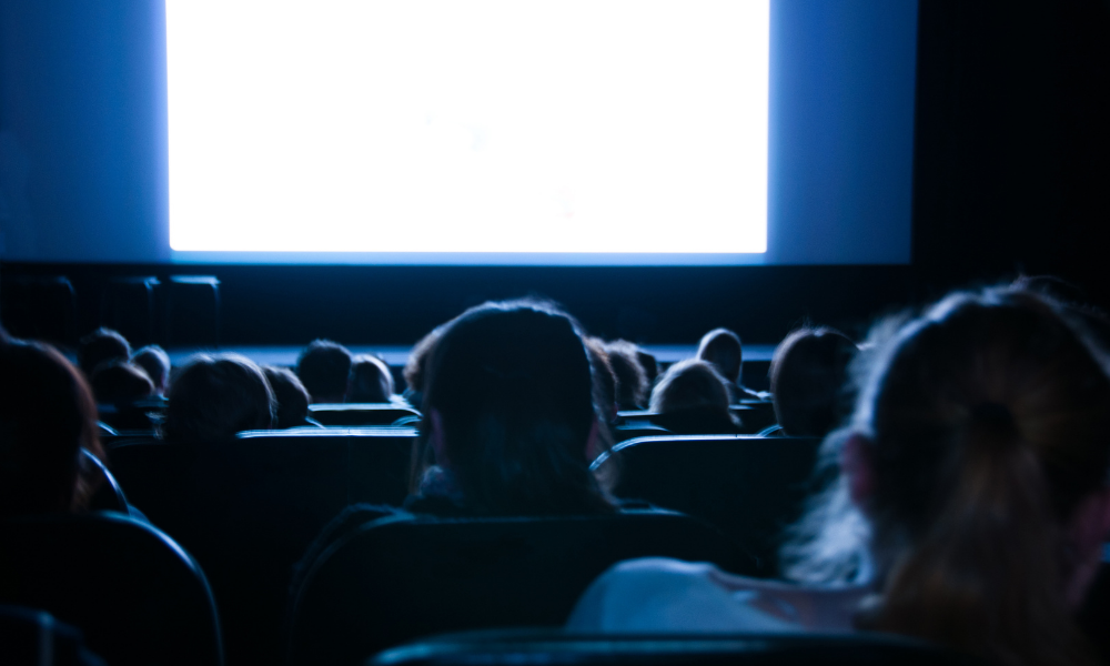 People sit facing a screen in a cinema