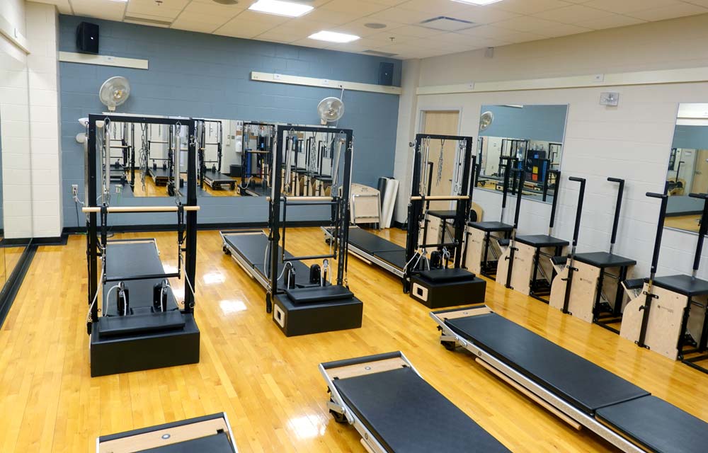 Studio B with pilates machines lined up in a row