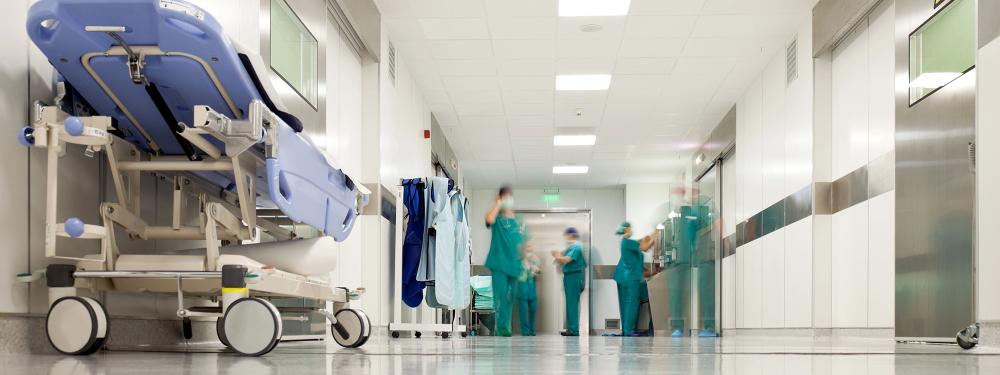 People in hospital scrubs walking down a hospital hallway.