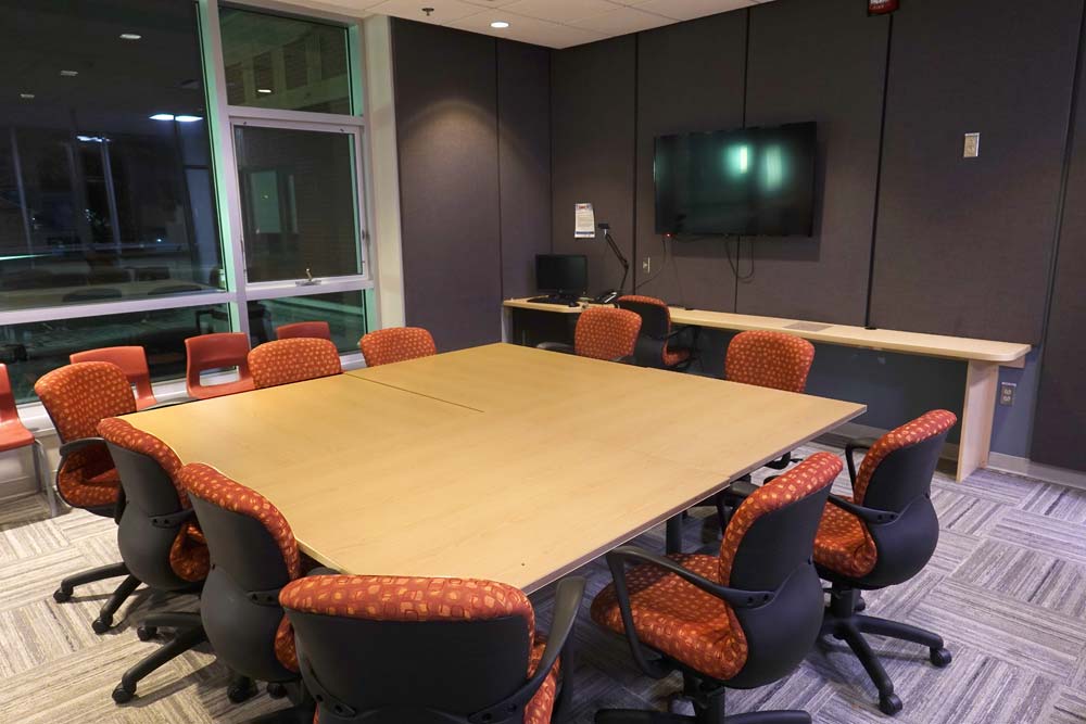 Meeting room with square table in the centre and chairs sourounding table.