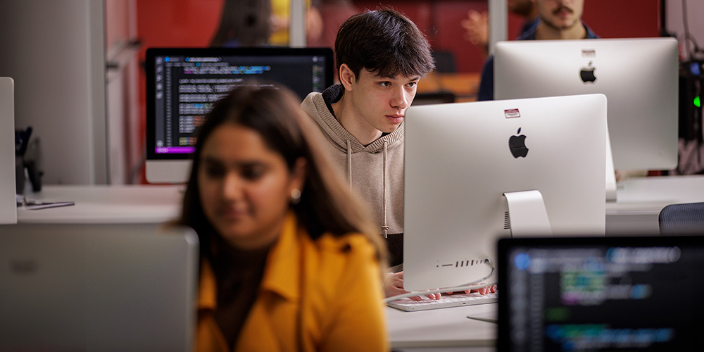 Students stare intently at their computer screens.