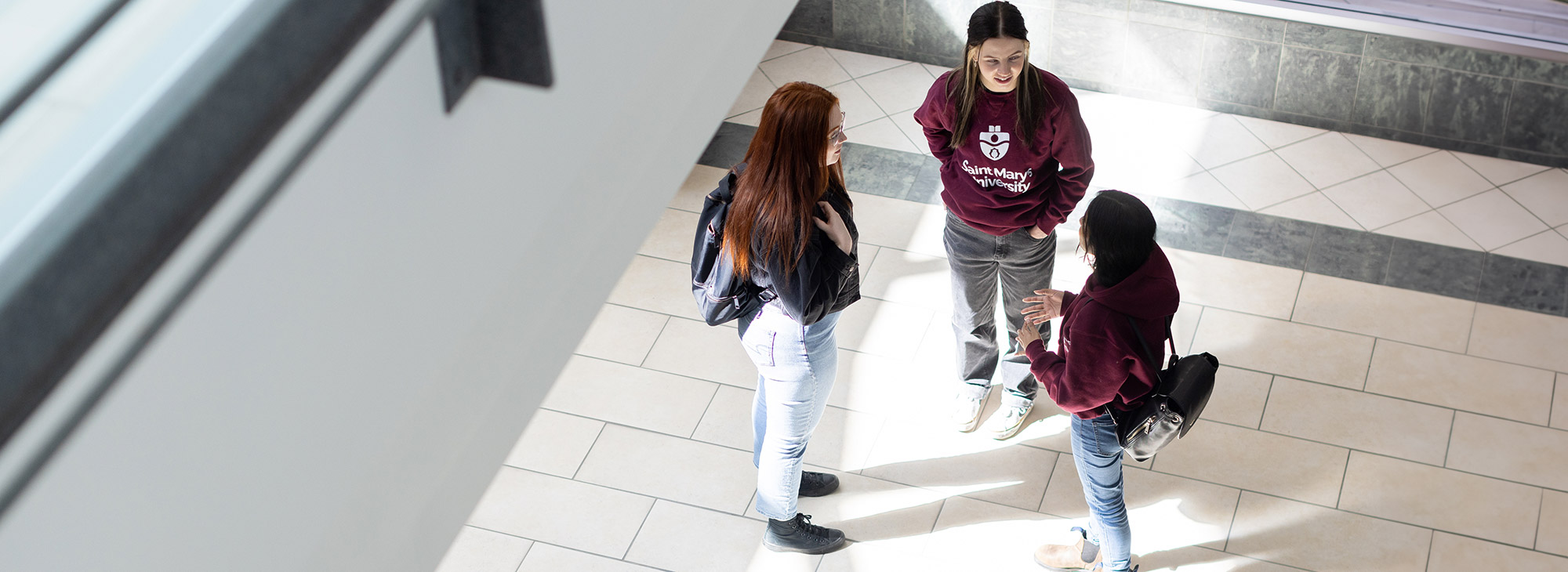 Three chatting students photographed from above.